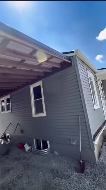 Lateral exterior terminado con siding gris
